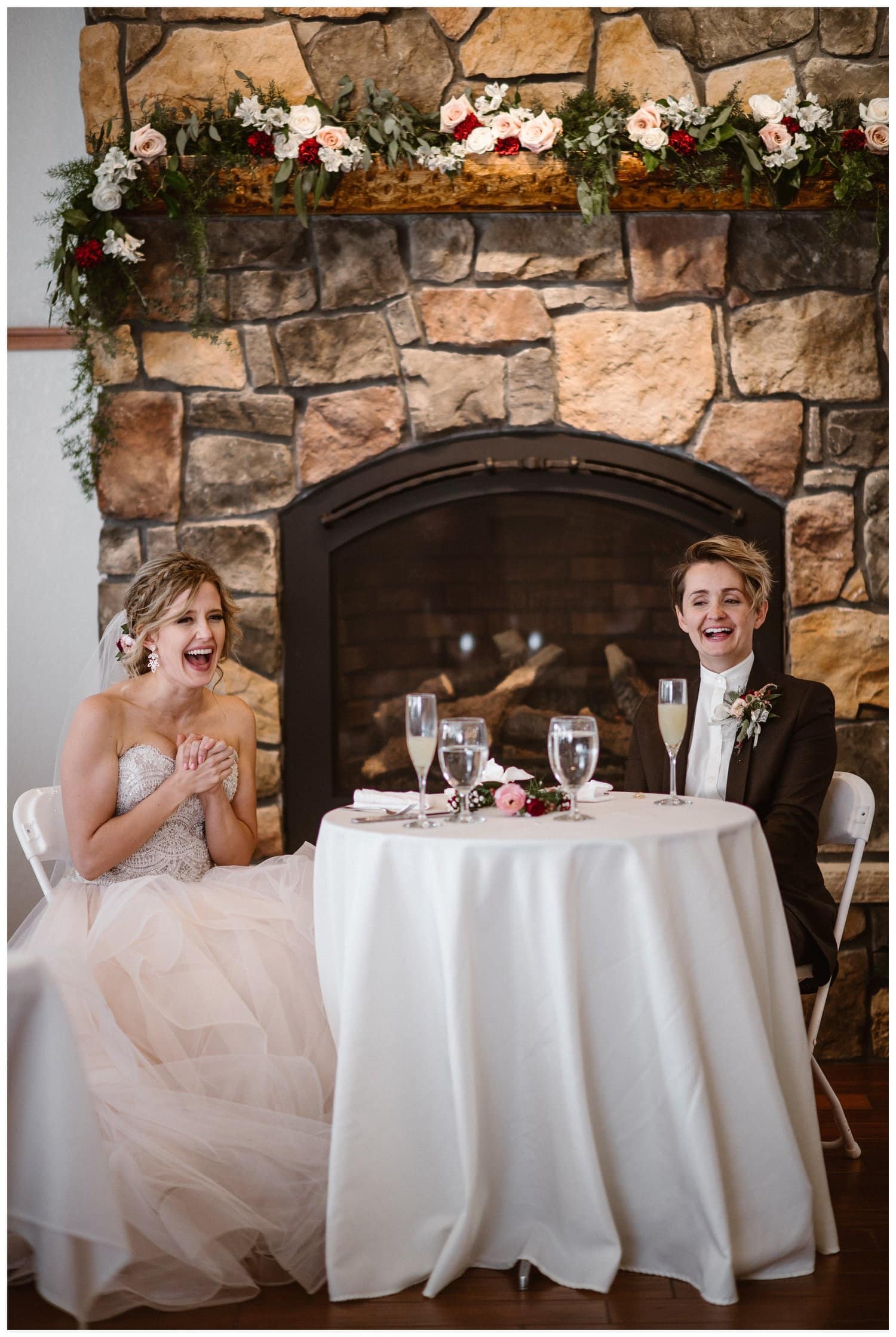 Two brides sitting at a table during their reception at Black Canyon Inn in Estes Park, Colorado. 