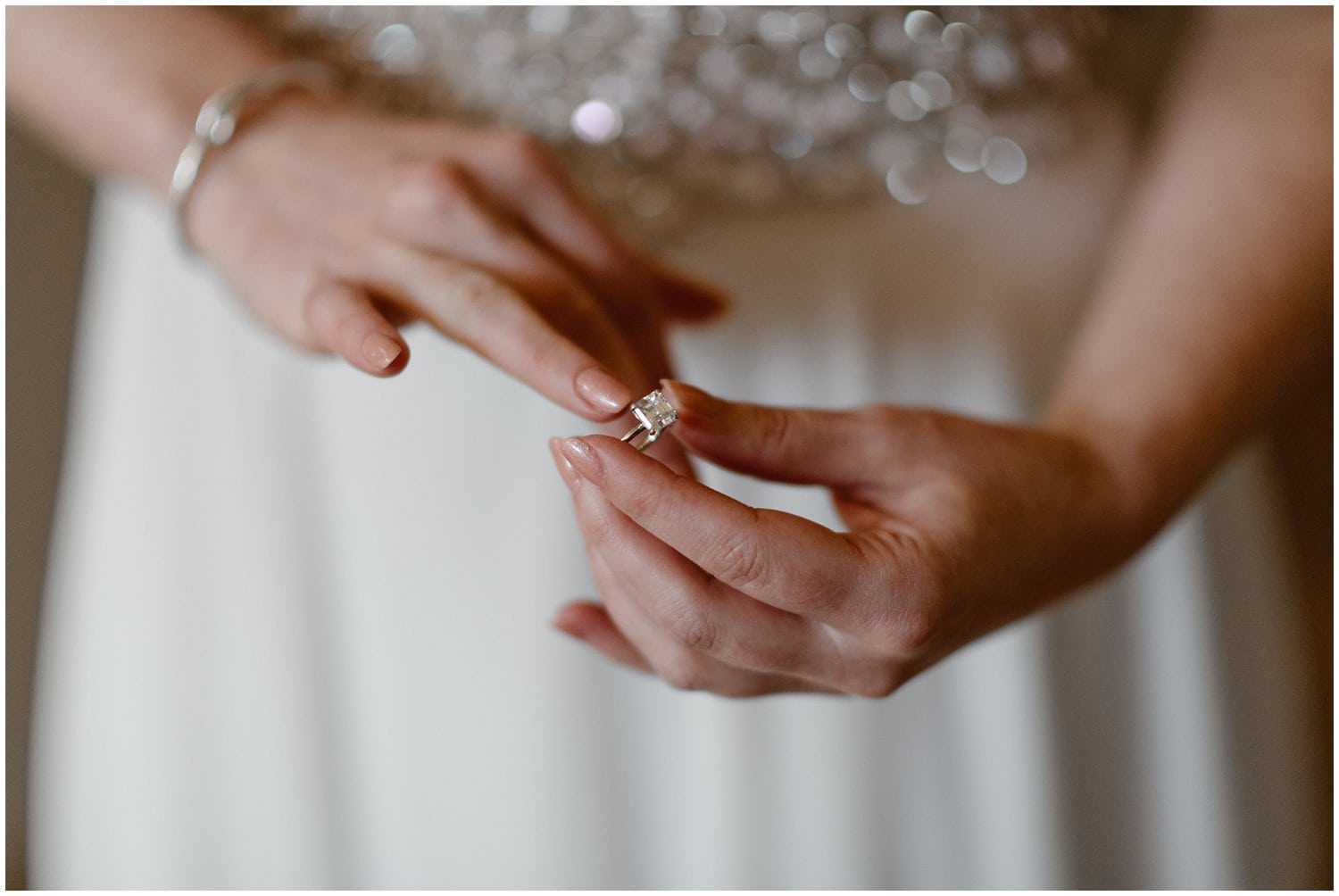 Close-up of bride putting ring on ring finger. 