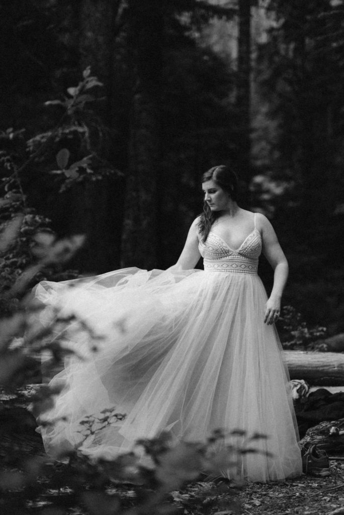 Bride plays with the skirts of her dress as it flows beside her. 