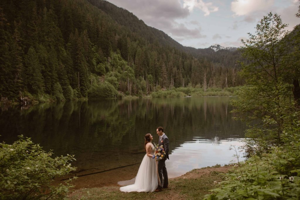 Bride and groom during lakeshore ceremony in Washington State Forest. 