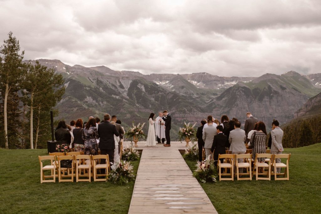 A bride and groom have an intimate wedding ceremony in the mountains with their family and friends.