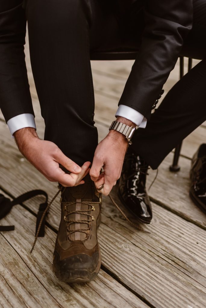 Close up of groom tying shoe laces. 