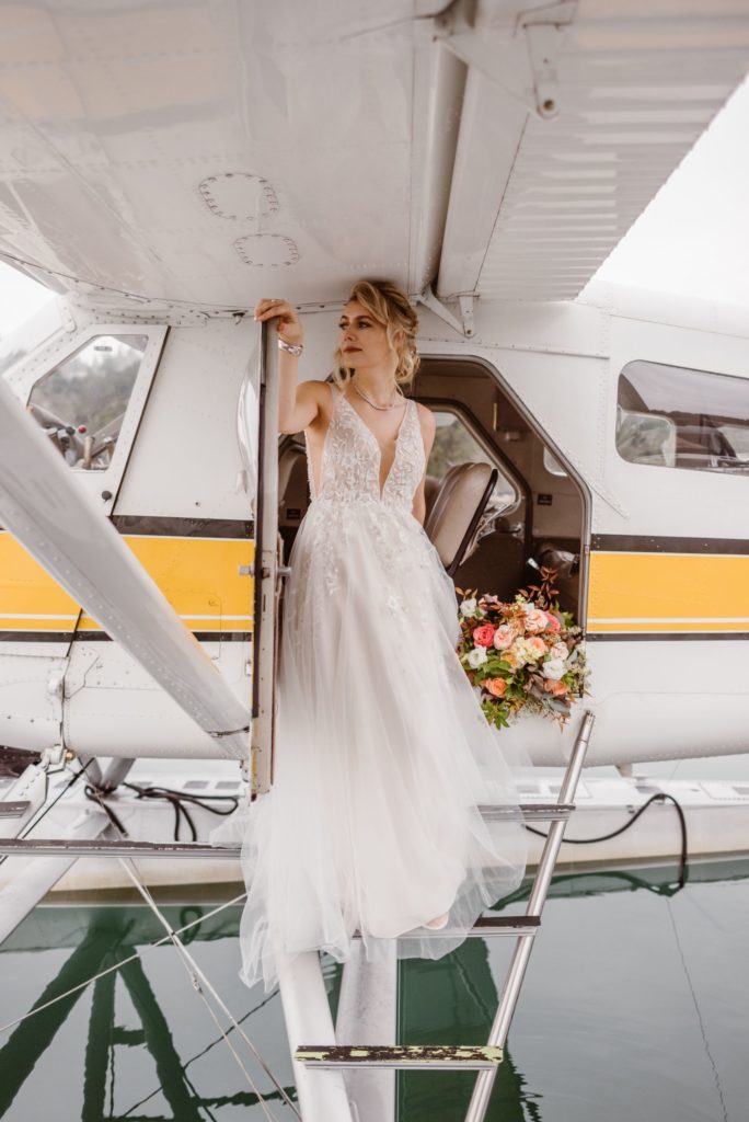 Bride stands in doorway of floatplane.