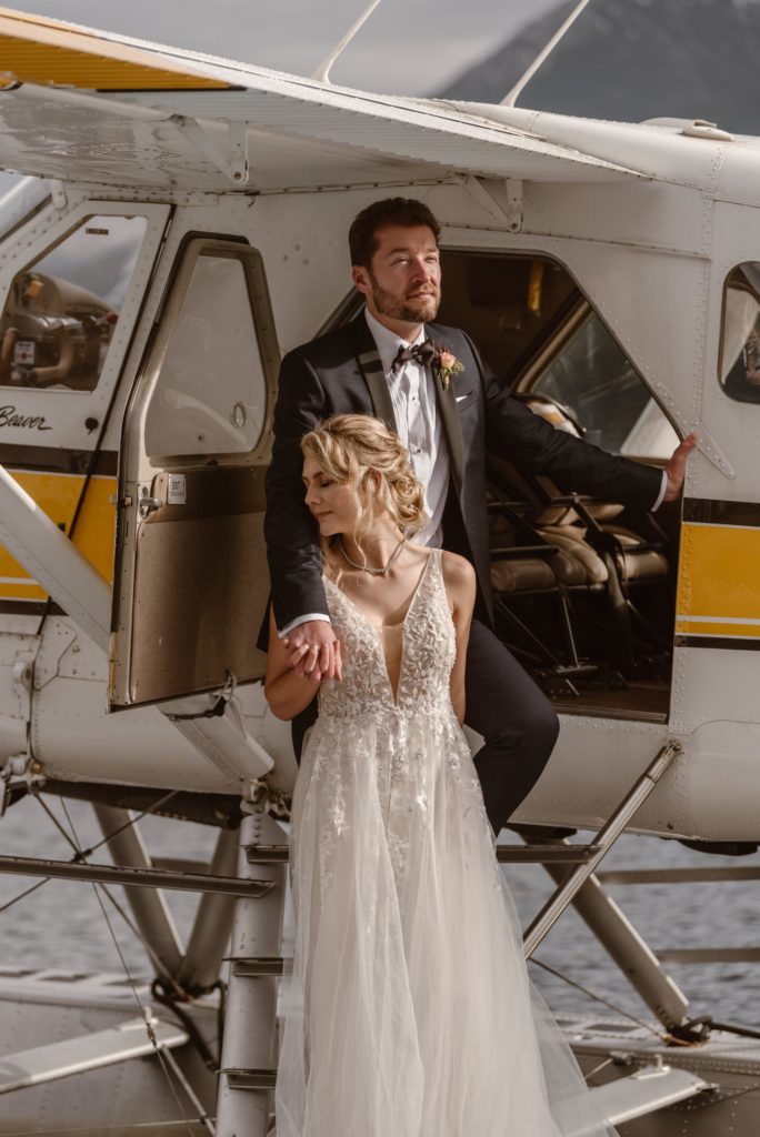 Bride and groom stand on exterior of floatplane